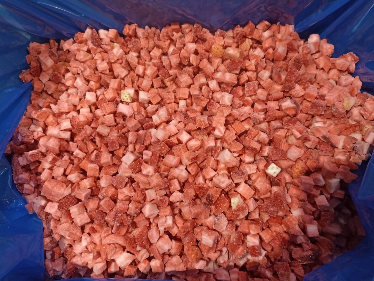 Finely diced frozen strawberries, showing consistency for industrial use.
