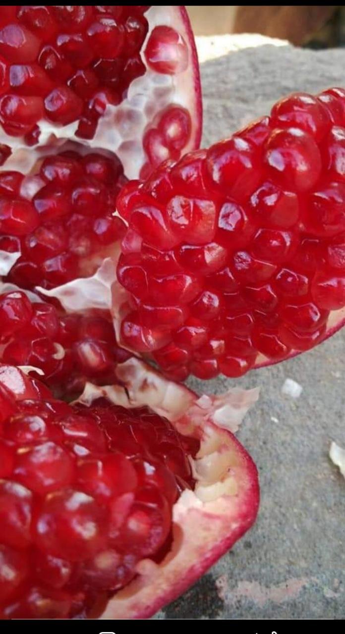 A close-up of a pomegranate split open, revealing its juicy, gem-like seeds.